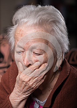 Portrait of old gray-haired sad woman