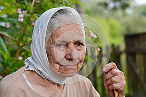 Portrait of old lonly woman in headscarf. Elderly woman