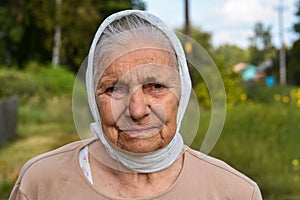 Portrait of old lonly woman in headscarf. Elderly woman