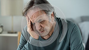 Portrait of old man with hand on forehead