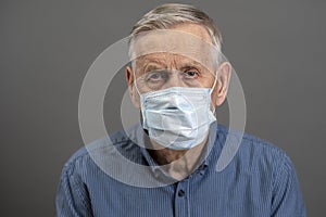 Portrait of an old man in a medical protective mask.