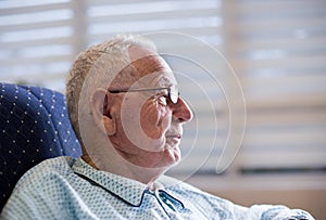 Portrait of old man in pajamas on sofa