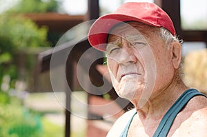 Portrait of an old man in a red baseball cap