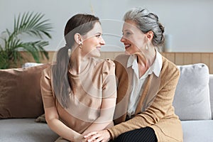 Portrait of old mother and mature daughter hugging at home. Happy senior mom and adult daughter embracing with love