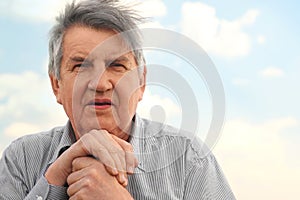 Portrait of old serious senior in striped shirt