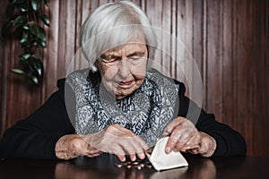 Portrait of an old woman counting money. The concept of old age, poverty, austerity. photo