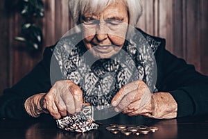 Portrait of an old woman counting money. The concept of old age, poverty, austerity. photo