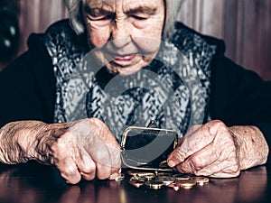 Portrait of an old woman counting money. The concept of old age, poverty, austerity. photo