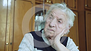 Portrait of old wrinkled tired alone grandmother looking at camera. 4k