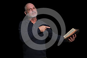 portrait of older man with beard doing reading isolated on black background