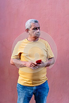 Portrait of an older man holding a cell phone