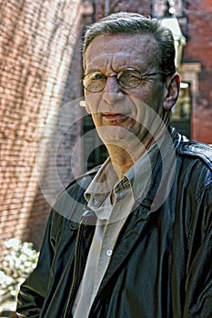 Portrait of older man squinting outdoors photo