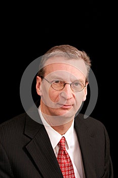 Portrait of older man in suit against black