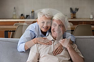 Portrait older wife cuddles husband laughing spend time at home