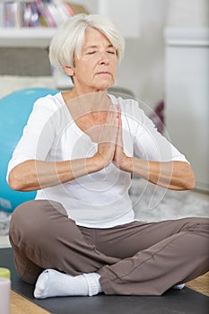 portrait older woman in sportswear exercising at home