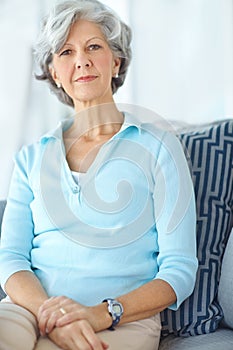 Portrait of one happy senior caucasian woman with grey hair at home. Face and neck of a cheerful retired lady showing
