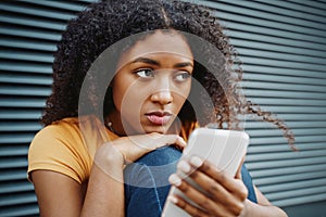 Portrait of one lonely black girl using cellphone