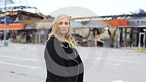 Portrait of one lonely young girl in soot against the background of a broken building