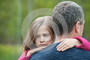 Portrait of one sad daughter hugging  her father