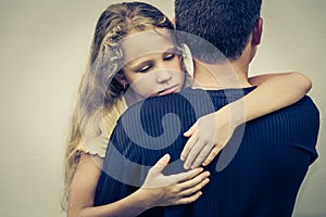 Portrait of one sad daughter hugging his father