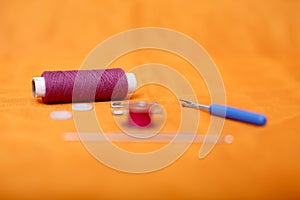 Portrait of one sewing thread, needle, bobbin, button, safety pin and needle ripper