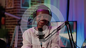 Portrait of online radio host smiling confident at camera while broadcasting live using professional equipment