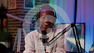 Portrait of online radio host smiling confident at camera while broadcasting live using professional equipment