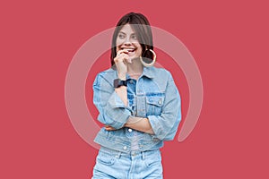 Portrait of optimistic dreamy beautiful brunette young woman with makeup in denim casual style standing, toothy smiling and