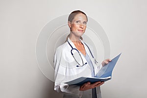 Portrait of optimistic mid adult female doctor indoor