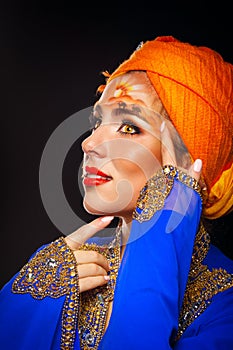 Portrait of oriental beauty in a turban and face art.