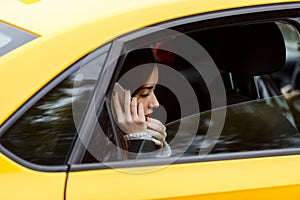 Portrait out window car of pensive woman talking on cellphone