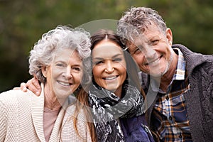 Portrait, outdoor and senior parents with adult daughter, embrace and happy with nature and bonding together. Face