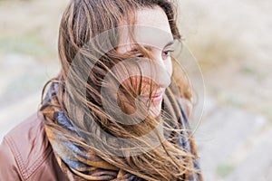 Retrato afuera de mujer joven viento conmovedor su cabello 