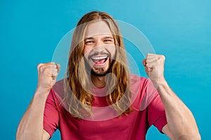 Portrait of overjoyed positive person raise fists accomplishment attainment isolated on blue color background