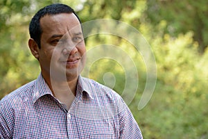 Portrait of overweight Indian businessman at the park outdoors