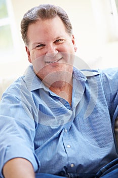 Portrait Of Overweight Man Sitting On Sofa