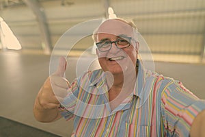 Portrait of overweight senior tourist man exploring around the city