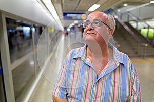 Overweight senior tourist man exploring around the city of Bangk photo