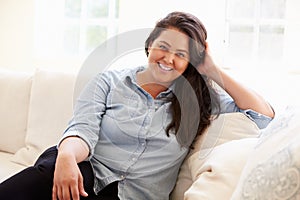 Portrait Of Overweight Woman Sitting On Sofa