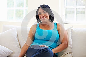 Portrait Of Overweight Woman Sitting On Sofa