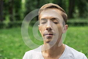 Portrait of the pacified face of a young attractive man with his eyes closed photo