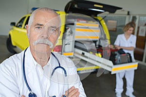 Portrait paramedic with ambulance in background
