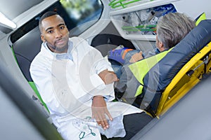 Portrait paramedic in ambulance with patient