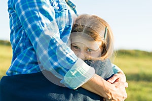 Portrait of parent and child. Mother hugs her little daughter. Nature background, rural landscape, green meadow, close-up of child photo