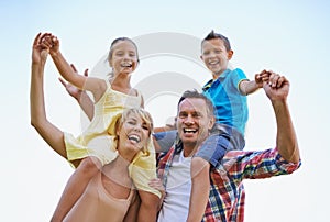 Portrait, parents and carrying children in park, shoulders and quality time in nature. Love, smile and joyful with happy
