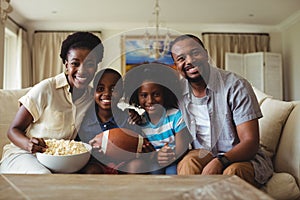 Portrait of parents and kids watching television in living room