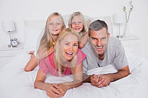 Portrait of parents lying in bed with their twins