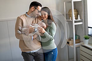 Portrait of parents and newborn baby. Father and mother kiss and hug a beautiful newborn child. .