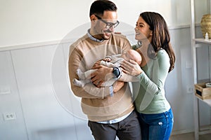 Portrait of parents and newborn baby. Father and mother kiss and hug a beautiful newborn child. .