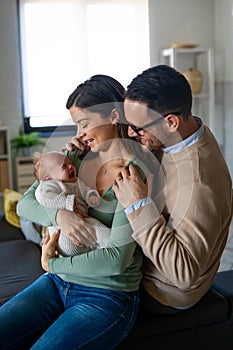 Portrait of parents and newborn baby. Father and mother kiss and hug a beautiful newborn child. .